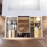 Badkamerinspiratie met groene meubels in speciale kleur met zijden van natuurlijk eikenhout, elegante groeven, werkblad met ovale opzetwastafel, ovale spiegel en bloemenbehang geeft een sierlijke, retro uitstraling.