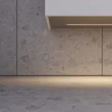 Stijlvolle badkamer inspiratie met beige wastafelmeubel met binnenlade, bovenkast, open plank, ovale spiegel met verlichting, bijpassende hanglampen, plank onder de spiegel en wandgemonteerd toilet. Wanden met lichte, langwerpige tegels