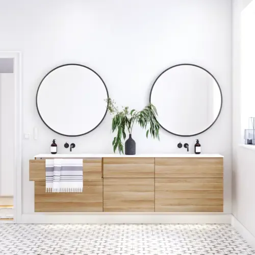 Scandinavische badkamer in hout met mooie ronde spiegels met zwarte randen en veel opbergruimte in het badkamermeubel