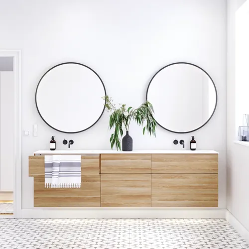 Scandinavische badkamer in hout met mooie ronde spiegels met zwarte randen en veel opbergruimte in het badkamermeubel