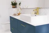 Badkamerinspiratie met badkamermeubels in moderne blauwe kleur, elegante opzetwastafel en grote vierkante spiegel met verlichting, witte visgraattegels zorgen voor een stijlvolle en klassieke uitstraling