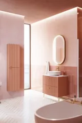 Grote vintage badkamer met terracottakleurig wastafelmeubel, opzetwastafel, ovaal spiegel met messingrand, roze en grijze tegels voor een romantische, vrouwelijke uitstraling
