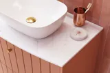 Grote vintage badkamer met terracottakleurig wastafelmeubel, opzetwastafel, ovaal spiegel met messingrand, roze en grijze tegels voor een romantische, vrouwelijke uitstraling