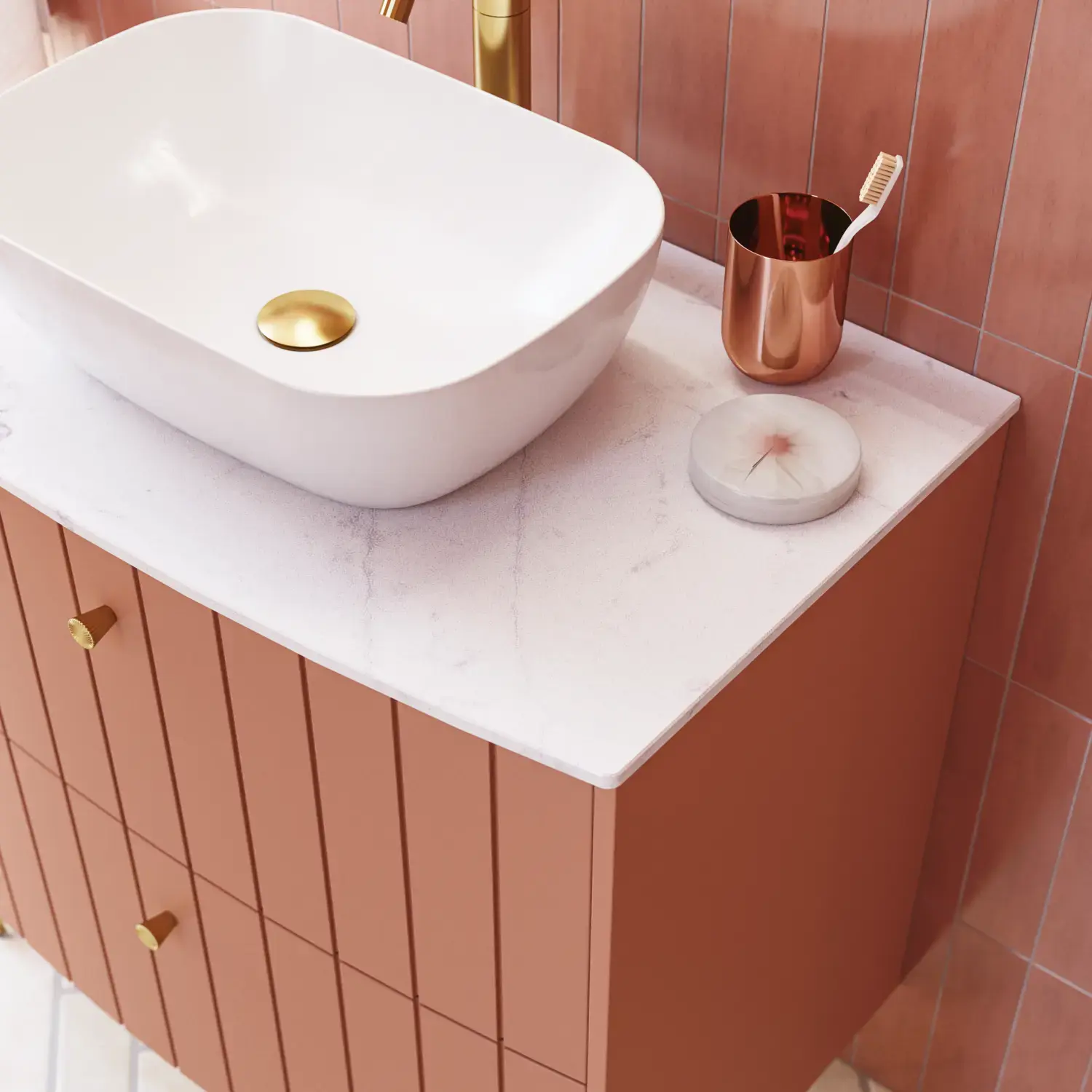 Grote vintage badkamer met terracottakleurig wastafelmeubel, opzetwastafel, ovaal spiegel met messingrand, roze en grijze tegels voor een romantische, vrouwelijke uitstraling