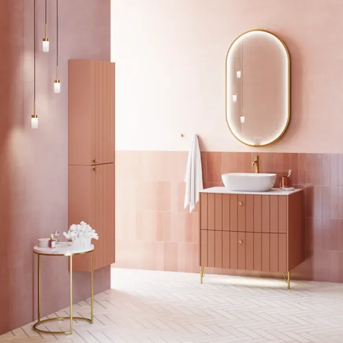 Grote vintage badkamer met terracottakleurig wastafelmeubel, opzetwastafel, ovaal spiegel met messingrand, roze en grijze tegels voor een romantische, vrouwelijke uitstraling