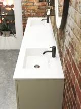 Moderne stoere badkamer in urban stijl. Mooie wastafelkasten en ronde spiegels met zwarte randen