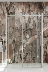 Badkamerinspiratie met luxe douchecabine met schuifdeur, witte badkamermeubels en een muur met ruwe look die de badkamer een rauw en stedelijk gevoel geeft
