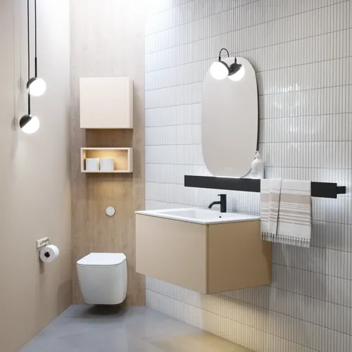 Stijlvolle badkamer inspiratie met beige wastafelmeubel met binnenlade, bovenkast, open plank, ovale spiegel met verlichting, bijpassende hanglampen, plank onder de spiegel en wandgemonteerd toilet. Wanden met lichte, langwerpige tegels