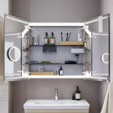 Kleine badkamerinspiratie met wastafelkast en kast boven het toilet in beige speciale kleur, elegante spiegelkast met geïntegreerde verlichting, de lichte kleuren en het witte gordijn creëren een romantische en vrouwelijke sfeer.
