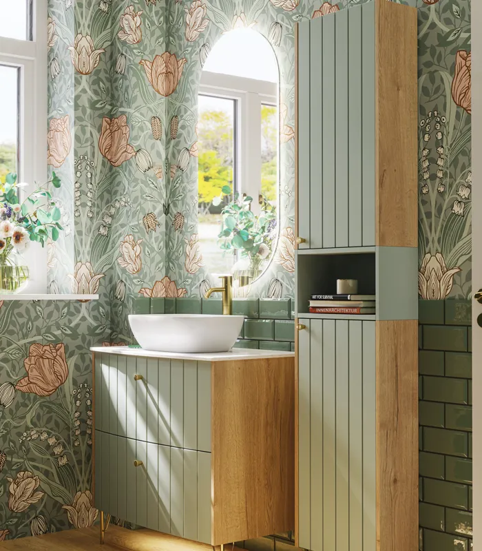 Badkamerinspiratie met groene meubels in speciale kleur met zijden van natuurlijk eikenhout, elegante groeven, werkblad met ovale opzetwastafel, ovale spiegel en bloemenbehang geeft een sierlijke, retro uitstraling.