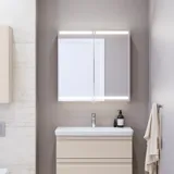 Kleine badkamerinspiratie met wastafelkast en kast boven het toilet in beige speciale kleur, elegante spiegelkast met geïntegreerde verlichting, de lichte kleuren en het witte gordijn creëren een romantische en vrouwelijke sfeer.