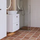 Grote badkamerinspiratie met witte meubels met ribbels, elegante aanrechtbladen en opzetwastafels, ovale spiegels met verlichting, zichtbare balken en patroontegels geven een vintage en stijlvol uiterlijk