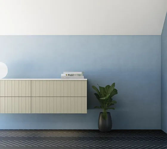 Badkamer met schuin plafond, beige meubels met groeven, elegante werkblad en vierkante wastafel, mooie spiegel met planken, blauwe muren, grote ramen en zwarte visgraatvloer geven een lichte, stedelijke uitstraling.