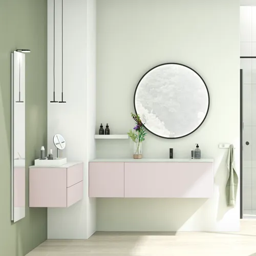 Grote en lichte badkamer in minimalistische stijl met zachte pasteltinten en elegante groene tinten, stijlvolle ronde spiegel en moderne inrichting