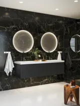 Elegante en moderne badkamer inspiratie met donkere marmeren muren, ronde verlichte spiegels met zwarte rand, wandgemonteerde wastafelkast met dubbele wastafel en een ruime douchehoek