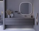 Grote badkamerinspiratie met grijs badmeubel met geïntegreerde handgreep, stijlvolle wastafel aan de zijkant, vierkante spiegel met afgeronde hoeken, betonlook muren en ruwe materialen voor een urban look