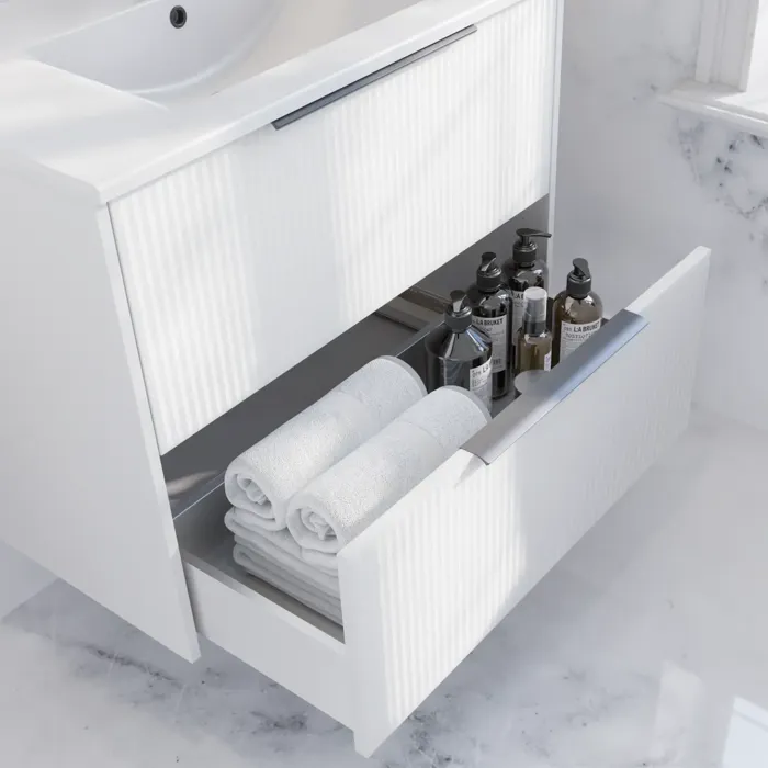 Badkamerinspiratie met wit badmeubel met elegante groeven en mooie wastafel, wit marmeren muren en vloer voor een heldere en moderne look.