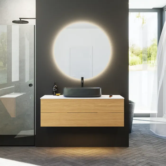 Minimalistische en stijlvolle badkamer inspiratie met wastafelmeubel, onderkasten en hoge kasten in gouden eik, grote ronde spiegel met lichtregeling, gekleurd toilet en vrijstaande wastafel