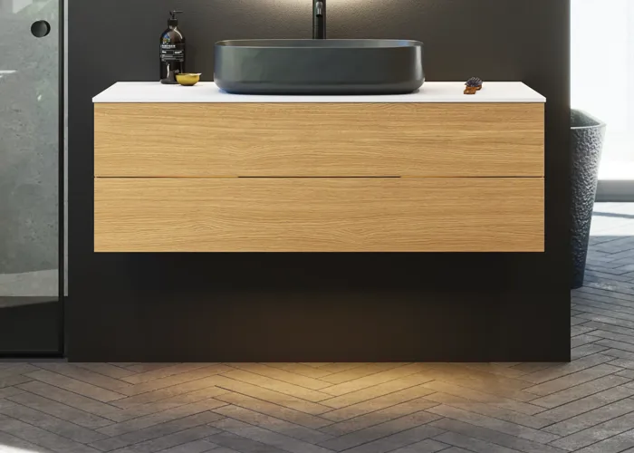 Minimalistische en stijlvolle badkamer inspiratie met wastafelmeubel, onderkasten en hoge kasten in gouden eik, grote ronde spiegel met lichtregeling, gekleurd toilet en vrijstaande wastafel