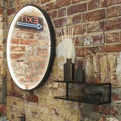 Moderne stoere badkamer in urban stijl. Mooie wastafelkasten en ronde spiegels met zwarte randen