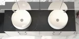 Romantische badkamer inspiratie met spiegelkast met praktische en sierlijke opbergoplossingen, dubbele vrijstaande wastafels op een stenen aanrechtblad.