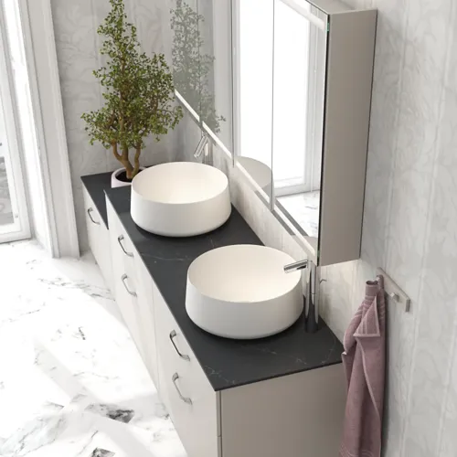 Romantische badkamer inspiratie met spiegelkast met praktische en sierlijke opbergoplossingen, dubbele vrijstaande wastafels op een stenen aanrechtblad.