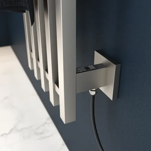 Elektrische handdoekwarmer op een donkerblauwe muur in een stijlvolle badkamer.