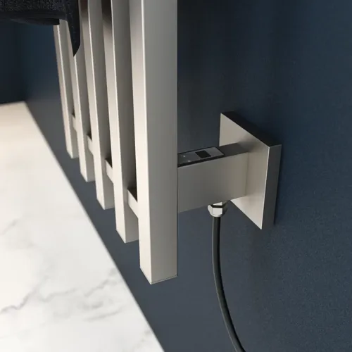 Elektrische handdoekwarmer op een donkerblauwe muur in een stijlvolle badkamer.