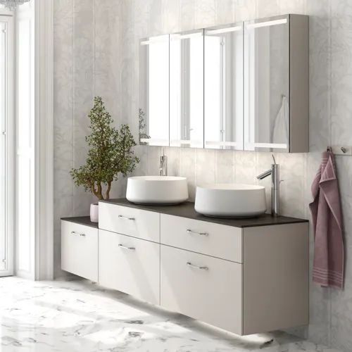 Romantische badkamer inspiratie met spiegelkast met praktische en sierlijke opbergoplossingen, dubbele vrijstaande wastafels op een stenen aanrechtblad.