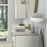 Grote en romantische badkamer met ronde spiegel met goudkleurige rand