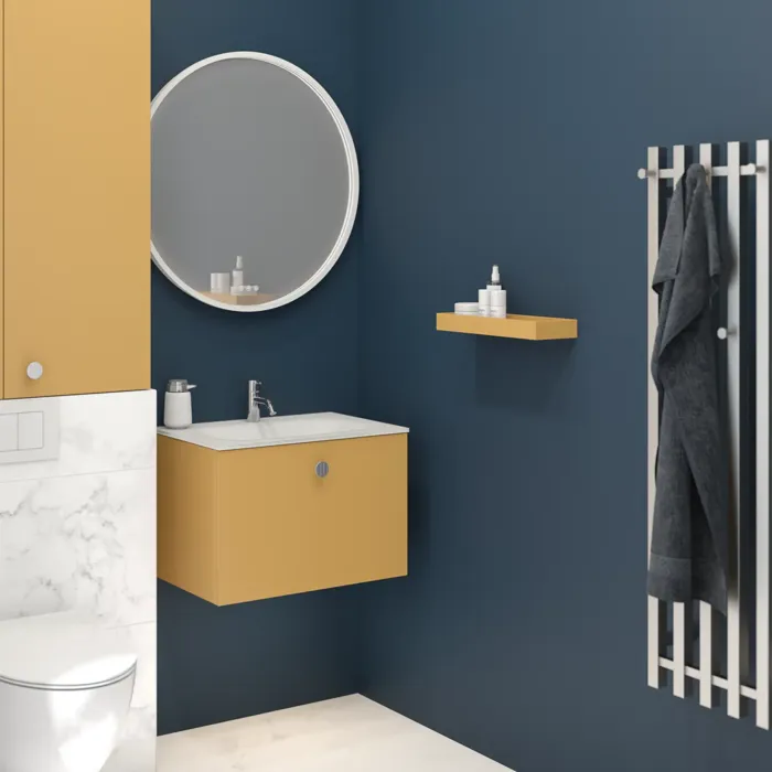 Kleine badkamer met donkerblauwe muren en zachte gele tinten, ronde spiegel en elegante elektrische handdoekwarmer.