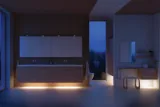 Moderne badkamer in Noordse stijl met licht hout, elegante verlichting, spiegelkastmuur en stijlvolle inrichting die een warme en uitnodigende sfeer creëert.