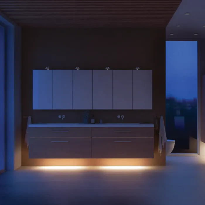 Moderne badkamer in Noordse stijl met licht hout, elegante verlichting, spiegelkastmuur en stijlvolle inrichting die een warme en uitnodigende sfeer creëert.