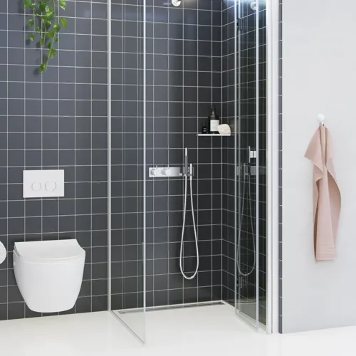 Badkamerinspiratie met een douchescherm met vaste wand en vouwdeur in helder glas en satijn dat een lichte en moderne uitstraling geeft.