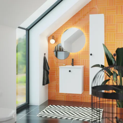 Badkamer met schuin plafond inspiratie met klein wit badmeubel en hoge kast met ronde zwarte handgrepen, evenals mooie ronde spiegel, oranje tegels geven een frisse en moderne look.