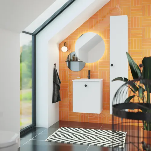 Badkamer met schuin plafond inspiratie met klein wit badmeubel en hoge kast met ronde zwarte handgrepen, evenals mooie ronde spiegel, oranje tegels geven een frisse en moderne look.