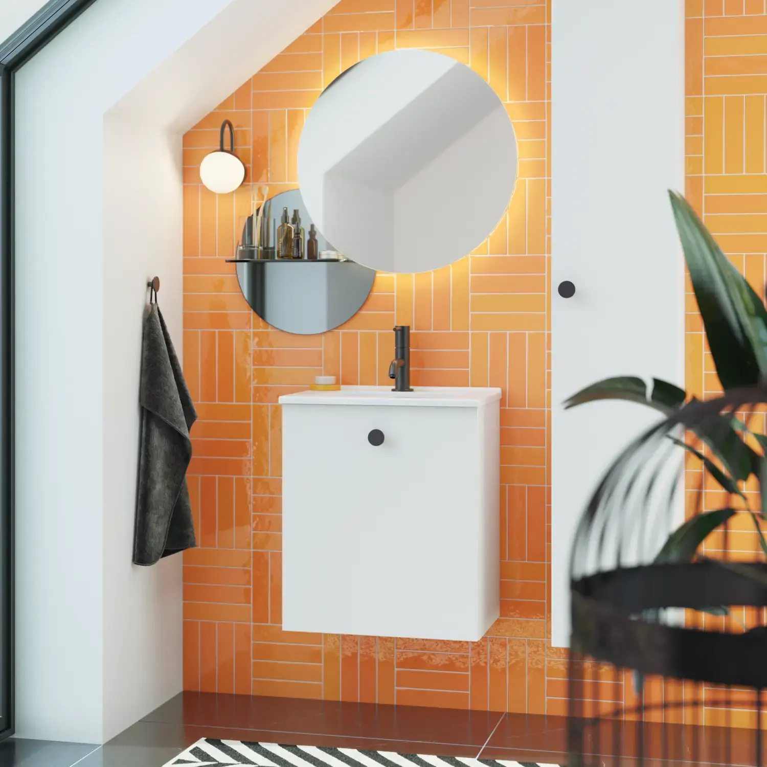 Badkamer met schuin plafond inspiratie met klein wit badmeubel en hoge kast met ronde zwarte handgrepen, evenals mooie ronde spiegel, oranje tegels geven een frisse en moderne look.