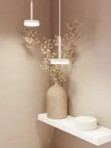 Badkamerinspiratie, waar een roze wastafelmeubel met geïntegreerde grepen en een dunne elegante wastafel wordt gecombineerd met een ronde spiegel en roze tegels, wat een vrouwelijke en romantische stijl creëert.