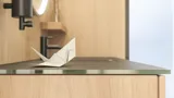 Stijlvolle badkamer in Scandinavische en Japandi stijl met lichte houten muren, ronde spiegel en minimalistische badkamermeubels.