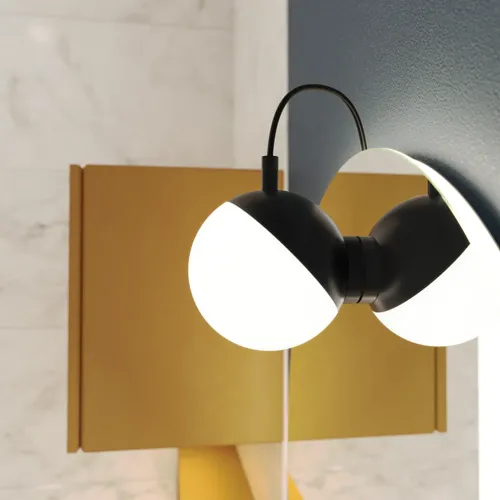 Spiegel lamp met zachte vormen op een donkerblauwe muur in een stijlvolle badkamer.