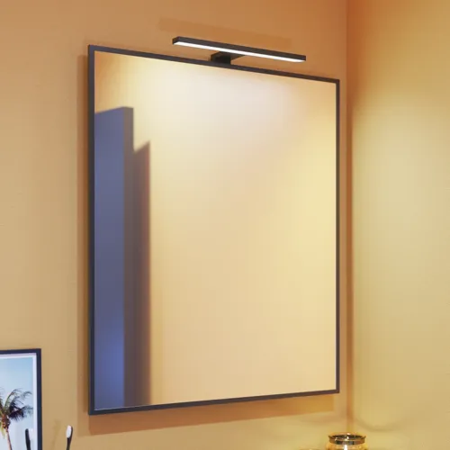 Kleine badkamerinspiratie met schuine, warme gele muren en een minimalistische vierkante spiegel met een strakke zwarte rand, samen met een elegante spiegelverlichting die een vleugje elegantie aan je badkamer toevoegt.