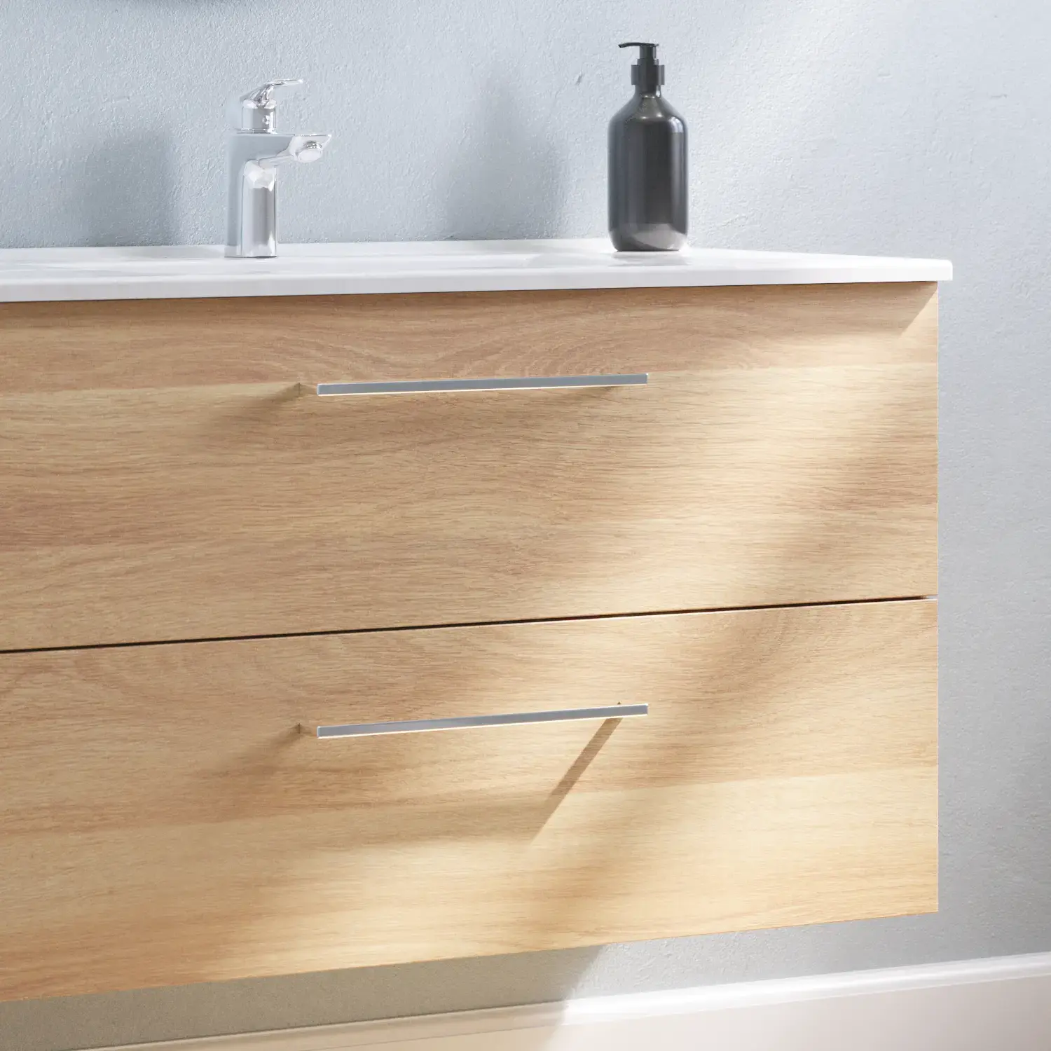 Grote badkamerinspiratie met badmeubel in Warm Eiken met elegante wastafel, chromen handgrepen en mooie ronde spiegel met zwarte rand en licht, visgraatvloer en grijze muren voor een moderne look.