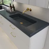 Grote badkamerinspiratie met elegante stenen wastafel in Charcoal Soapstone met stijlvol wit badmeubel met messing handgrepen en mooie spiegelkast met stenen vloer voor een exclusieve en moderne uitstraling.