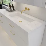 Grote badkamerinspiratie met elegante stenen wastafel in Eternal Statuario met stijlvol wit badmeubel met messing handgrepen en mooie spiegelkast met stenen vloer voor een exclusieve en moderne uitstraling.
