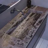 Grote badkamerinspiratie met grijs badmeubel met geïntegreerde handgreep, stijlvolle wastafel aan de zijkant, vierkante spiegel met afgeronde hoeken, betonlook muren en ruwe materialen voor een urban look