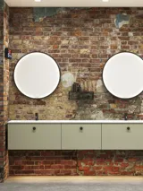 Moderne stoere badkamer in urban stijl. Mooie wastafelkasten en ronde spiegels met zwarte randen