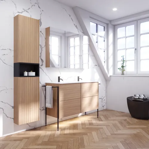 Badkamerinspiratie met wastafelkasten en bovenkasten in licht eikenhout met groeven, elegante dubbele wastafel, mooie spiegelkast met verlichting, visgraatvloer in licht hout en witte marmeren muur geven een klassieke, lichte en strakke uitstraling.