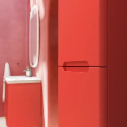 Badkamerinspiratie met rode muren, zacht gevormde rode wastafelmeubel en hoge kast, elegante witte wastafel en een prachtige ovale spiegel met licht die samen met de natuurlijke omgeving een vintage uitstraling creëren