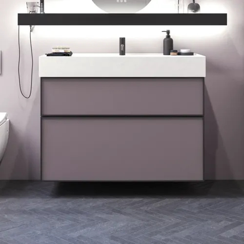 Badkamer met schuine muren, geïnspireerd door paarse badkamermeubels met elegante framefronten, mooie ovale spiegel met lamp, stijlvolle en praktische plank, paarse muur en grijze visgraatvloer, die een elegante en moderne uitstraling geven.
